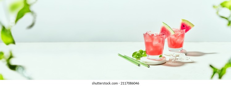 Fresh summer mocktail watermelon juice with ice in a two glass and glass straw on white background. Layout for wide banner with space for text. - Shutterstock ID 2117086046