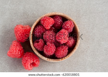 Fresh summer raspberry in a wooden bowl. Top view.