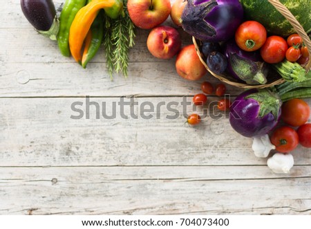 Fresh summer vegetables, collected in a basket of wicker, on a old wooden background.
