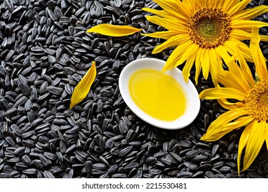 Fresh Sunflower Flower On A Background Of Black Seeds With A Bowl Of Sunflower Oil, Vegetable Oil By Cold Pressing. The Concept Of Vegetable Fats.