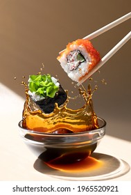 Fresh Sushi Roll Falling Into A Dish Of Soy Sauce With A Splash Of Liquid In A Freeze Motion.