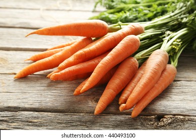 Свежая и сладкая морковь на сером деревянном столе