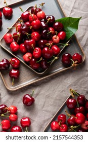 Fresh sweet cherry with green leaves on the linen tablecloth, selective focus image