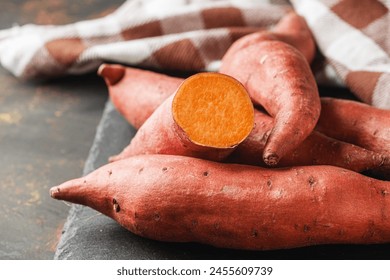 fresh sweet potatoes on a dark rustic background. - Powered by Shutterstock