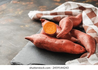 fresh sweet potatoes on a dark rustic background. - Powered by Shutterstock