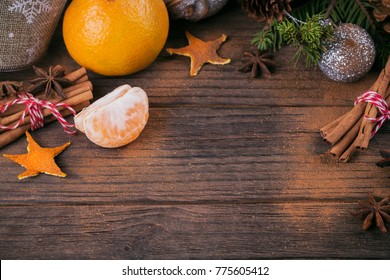 Fresh Tangerines with spices and Christmas decor with Xmas tree on dark old wooden table. Rustic style. Winter holiday concept. - Shutterstock ID 775605412