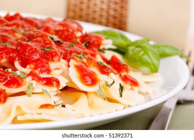 Fresh And Tasty Bowtie Pasta With Tomato Marinara Sauce And Basil Garnish