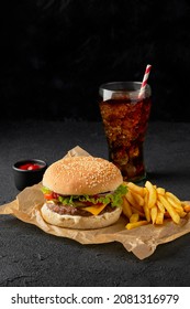 Fresh Tasty Burger, French Fries And Soft Drink On Dark Background