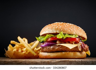 fresh tasty burger and french fries on wooden table