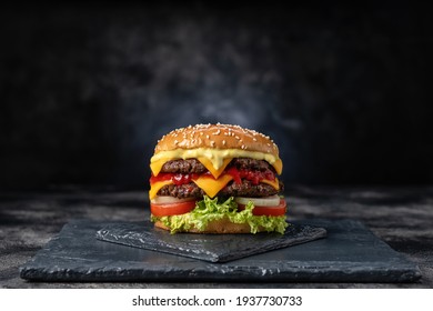 Fresh tasty burger on dark background - Shutterstock ID 1937730733
