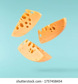 Fresh tasty cheese fall in the air isolated on turquoise background. Food levitation concept, high quality image