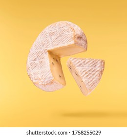 Fresh tasty cheese fall in the air isolated on yellow background. Food levitation concept, high quality image