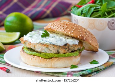 Fresh, tasty chicken burger in the Greek style with zucchini and yogurt cucumber sauce tzatziki, lime, salad - Powered by Shutterstock