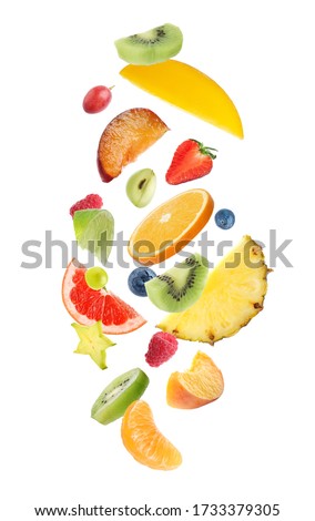 Fresh tasty fruits and berries falling on white background