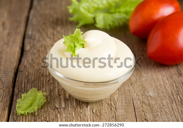 Frische, leckere Mayonnaise-Soße in Schüssel mit Gemüse (Tomaten, Salat ...