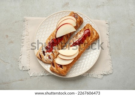 Fresh tasty puff pastry with jam and apples on white textured table, top view