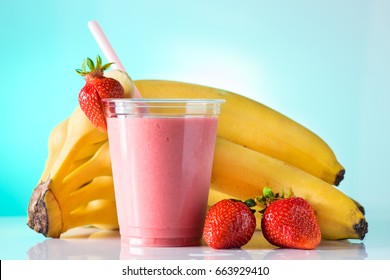 Fresh Tasty Strawberry Smoothie In Glass Cup With Drinking Straw On Azure Background. Strawberries And Banana Near The High Ball