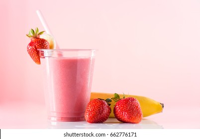 Fresh Tasty Strawberry Smoothie In High Ball With Drinking Straw On Pink Background. Strawberries And Banana Near The High Ball