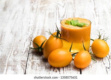 Fresh  tomato juice made from the golden-yellow tomatoes in glass on the table 