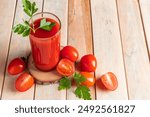 Fresh tomato juice on a wooden rustic background. Organic vegetable drink with parsley.