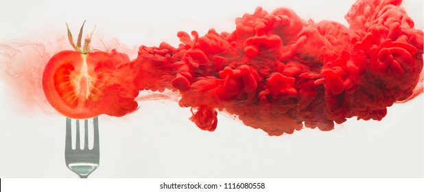 Fresh Tomato On A Fork With A Cloud Of Dissolving Color. Artistic Nutrition Concept. Science Of Food Action Photography