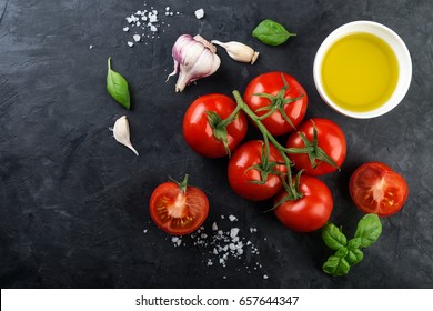 Fresh tomatoes, oil and spices on black stone background. Top view  - Powered by Shutterstock