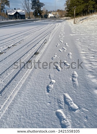 Fresh tracks of a man on the snow closed to the road
