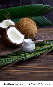 Fresh tropical coconuts on a rustic wooden table with palm leaves. Natural, exotic and organic composition perfect for food, wellness, and tropical lifestyle concepts