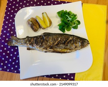 Fresh trout from the grill with potatoes from the potato pot and lemon butter. Plus fresh lamb's lettuce