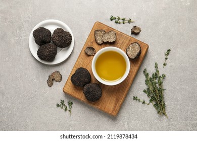 Fresh truffles, oil in bowl and thyme on light grey table, flat lay - Powered by Shutterstock