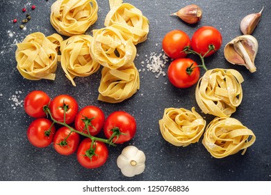 Fresh Uncooked Fettuccine Pasta With Tomatoes And Garlic.