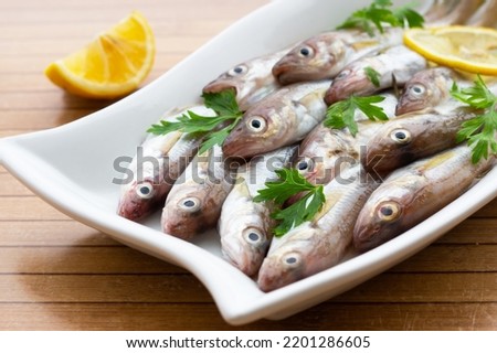 Fresh uncooked haddock fishes on in ceramic dish on table, raw whiting fish concept Foto stock © 