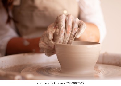 fresh unpainted ceramic bowl on a potter's wheel, ceramist's hands - Powered by Shutterstock