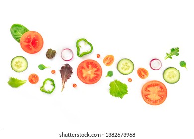 Fresh vegan vegetable salad ingredients, shot from the top on a white background. A flat lay composition with organic tomato, cucumber, peppers, onion slices and mezclun leaves
