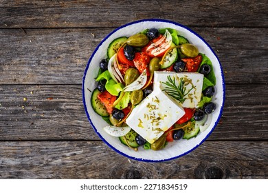 Fresh vegetable salad with feta cheese on wooden table 