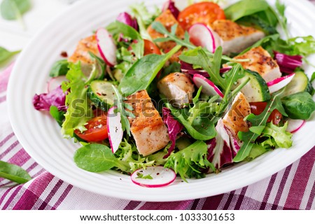 Fresh vegetable salad with grilled chicken breast   - tomatoes, cucumbers, radish and mix lettuce leaves. Chicken salad. Healthy food.