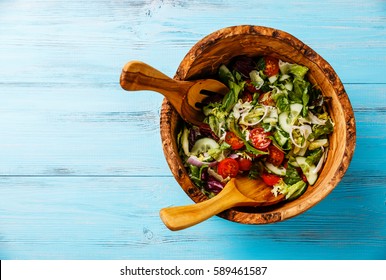 Fresh Vegetable Salad In Olive Wood Bowl On Blue Wooden Background Copy Space