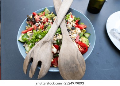 Fresh vegetable salad with tomatoes, cucumbers, seeds, and wooden salad servers. Healthy eating and summer food concept - Powered by Shutterstock