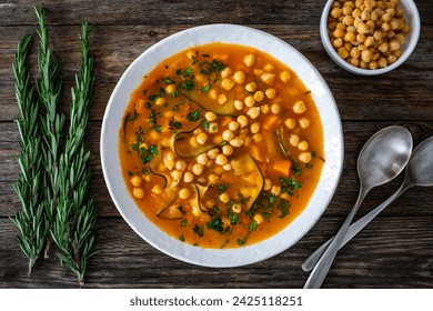 Fresh vegetable soup with chickpeas, zucchini and sweet potatoes on wooden table 