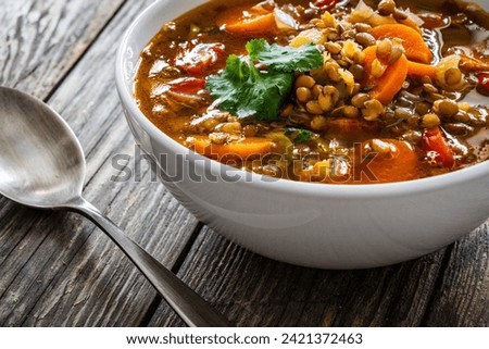 Fresh vegetable soup with lentil on wooden table 