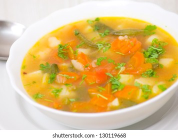 Fresh vegetable soup made of green bean, carrot, potato, red bell pepper, tomato in bowl