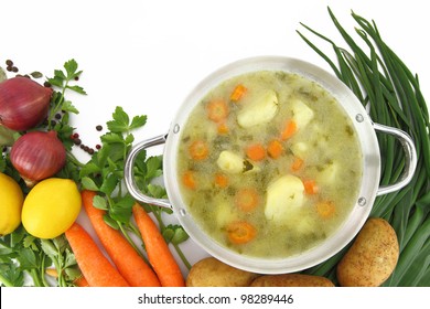 Fresh Vegetable Soup In A Pot With Mixed Vegetables Around It