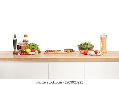 Fresh vegetables and a cutting board on a wooden kitchen counter isolated on white background - Powered by Shutterstock