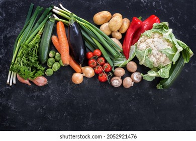 Fresh vegetables of different varieties on a dark slate background, diet food concept for fitness and lose weight, copy space, high angle view from above, selected focus - Powered by Shutterstock