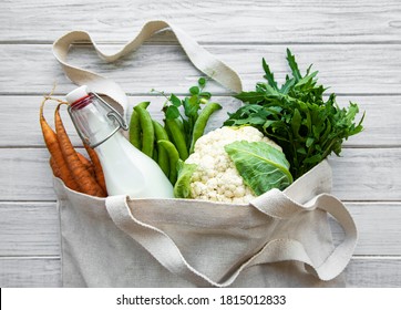 Fresh  vegetables in eco cotton bags on table in the kitchen.  Carrot,  green peas,  cabbage, milk and rucola from market. Zero waste shopping concept. - Powered by Shutterstock