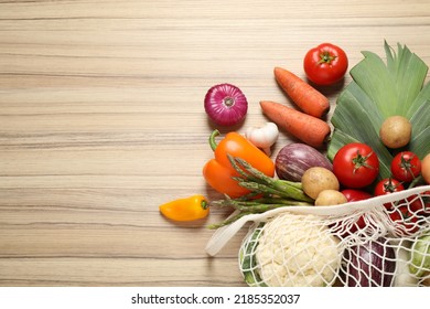 Fresh vegetables in eco mesh bag on wooden table, flat lay. Space for text - Shutterstock ID 2185352037