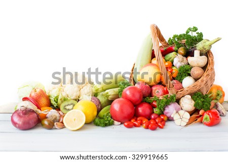 Fresh vegetables and fruit in basket on white background.