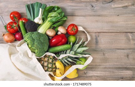 Fresh vegetables fruits in cotoon bag. Tomato, cucumber, broccoli, pineapple, avocado, banane, salad. Healthy food