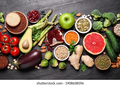 Fresh vegetables, fruits and seeds on black table, flat lay