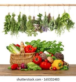 fresh vegetables and herbs on wooden background. raw food ingredients. shopping basket. kitchen interior